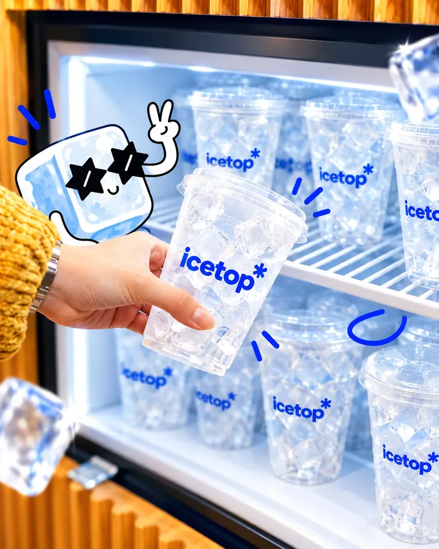 A hand taking an icetop Iceup cup of ice from a store freezer stocked with Iceup cups